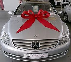 a silver car with a red bow on the hood