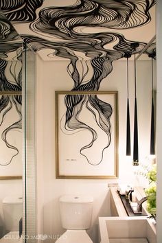 a bathroom with black and white artwork on the ceiling