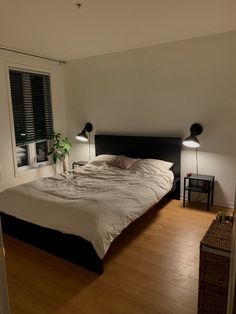 a bed sitting in the middle of a bedroom next to a window