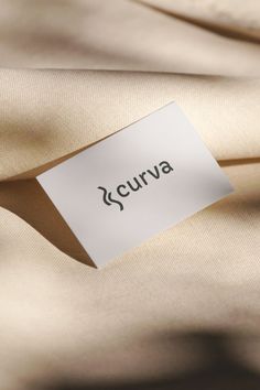 a label that says curva on it is attached to the fabric in front of an unbuttoned piece of cloth