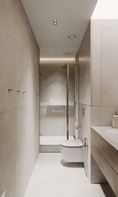 a bathroom with a toilet, sink and shower in it's center wall next to a long counter