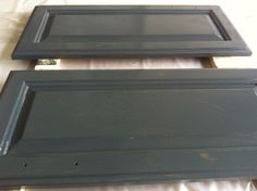 two black wooden doors sitting on top of a white sheet