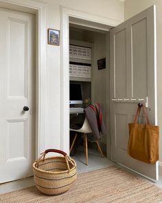 a basket sitting on the floor in front of a door with an open closet behind it