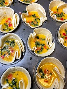 several tortillas filled with soup and vegetables in muffin tins on a baking tray