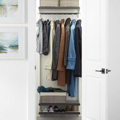 an open closet with clothes and shoes hanging on the rack, next to a door