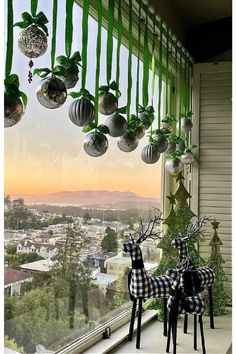 two deer statues sitting on top of a window sill