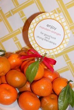 there is a pile of oranges on the table with a tag that says enjoy