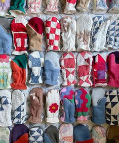 many pairs of mittens are lined up against a wall with different designs on them