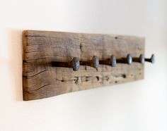 a coat rack made out of wooden planks with metal knobs on the hooks