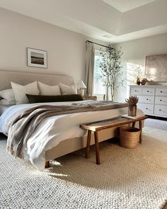 a bedroom with a large bed, dresser and window in it's center area