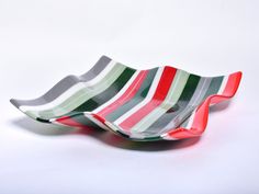 two striped bowls sitting side by side on a white surface with red, green and grey stripes