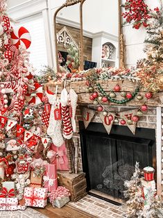 a decorated christmas tree in front of a fireplace with stockings and candy canes on the mantel