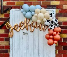 there is a sign that says yeehur and balloons are hanging on the door