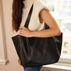 The one tote bag that can do everything. Take it from the office to the gym to an overnight, the slouchy, full-grain leather is endlessly versatile. Dynamic side panels fold out when the bag is full and elegantly drape inward on lighter days to maintain its classic architecture. Open interior slip pocket Secure interior zipper pocket Fits 15" laptop Unlined interior Soft, slouchy leather Dimensions: 20" W x 12" H x 6" D Handle Drop: 11.5" Bottom Width: 13" Looking for something smaller? Try the Classic Architecture, Picnic In The Park, The Times, Do Everything, Side Panels, Timeless Classic, Full Grain Leather, Zipper Pocket, First Time