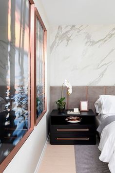 a bedroom with marble walls and white bedding