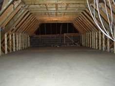 an attic with exposed walls and wooden beams on the ceiling is being constructed for storage