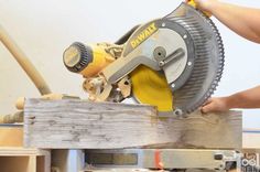 a person using a circular saw to cut wood planks with a miter attachment