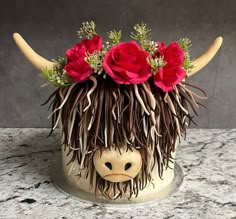 an animal head with flowers in it's hair on top of a marble counter