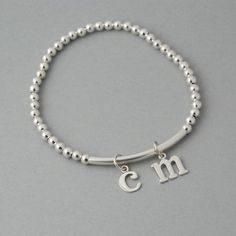 This is my new go to bracelet. Made for easy wear with high quality stretchy cord. Sterling silver beaded bracelet with a sterling bar. Silver initials dangle perfectly. Wear it alone or layered up! So cute. Listing is for one bracelet. **Please leave initial choices in notes at checkout** Comes in a Organza bag, gift box available or additional $2 PLEASE NOTE WHEN ORDERING, MEASURE YOUR WRIST, THEN ADD 1/2 INCH FOR A COMFORTABLE FIT. bracelet is adjustable by 1/2 inch. x-small 5-6 inches small Silver Stackable Charm Bracelet For Everyday, Silver Hypoallergenic Stretch Bracelet For Everyday, Silver Charm Bracelet With Letter Beads For Gift, Silver Charm Bracelet With Letter Beads As Gift, Personalized Silver Beaded Bracelets For Everyday, Adjustable Sterling Silver Charm Bracelet For Everyday, Silver Minimalist Stretch Bracelet As Gift, Everyday Adjustable Sterling Silver Charm Bracelet, Everyday Stackable Sterling Silver Stretch Bracelet