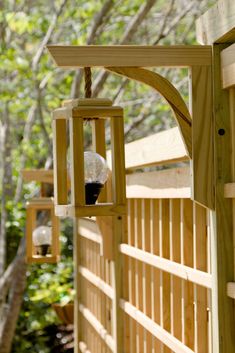 a bird feeder hanging from the side of a wooden fence