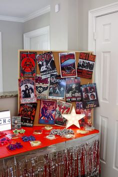 a red table topped with lots of pictures next to a white door covered in confetti