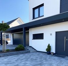 a house with two garage doors and steps leading to it's front door is shown