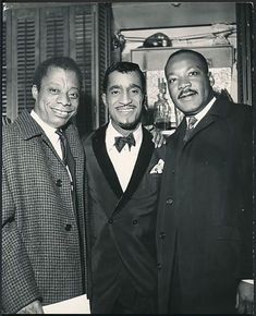 three men standing next to each other wearing suits