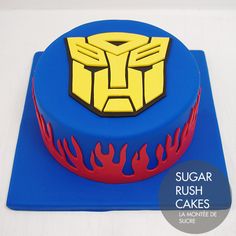 a blue cake topped with a yellow and red transformer symbol on top of a blue plate