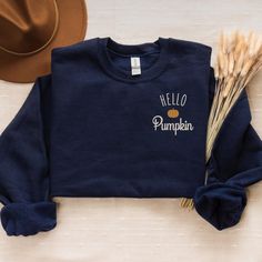 Welcome the cozy vibes of fall with our "Hello Pumpkin" embroidered crewneck! This comfy sweatshirt is made from a soft 50/50 cotton polyester blend, offering both warmth and durability. Whether you're sipping on a pumpkin spice latte or enjoying a crisp autumn walk, this crewneck is the perfect addition to your fall wardrobe. Product Details: Material: Cozy 50/50 cotton polyester blend for a soft, comfortable feel Design: Fall-themed "Hello Pumpkin" design featuring a charming pumpkin accent em Fall Wardrobe Staples, Fall Lovers, Autumn Walk, Crisp Autumn, Hello Pumpkin, Autumn Gifts, Cozy Socks, Embroidered Crewneck, Comfy Sweatshirt