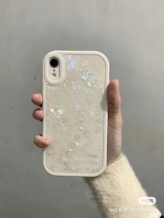 a person holding up a phone case with holographics on it