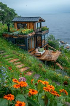 a house on the side of a hill with flowers growing out of it