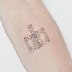 a small tattoo on the arm of a woman's arm with an old tv