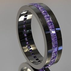 two wedding bands with purple stones in the center and one is made out of metal