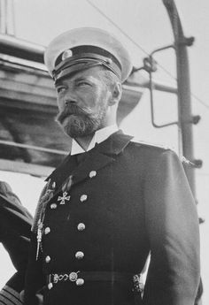 black and white photograph of a man in uniform standing next to a cable car with his hand on his hip