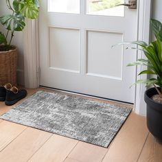 a pair of black shoes sitting on top of a wooden floor next to a door