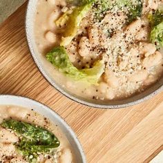 two bowls filled with food sitting on top of a wooden table next to each other