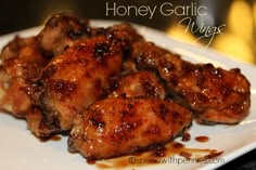 honey garlic wings on a white plate ready to be eaten for lunch or dinner, with the words honey garlic wings above it