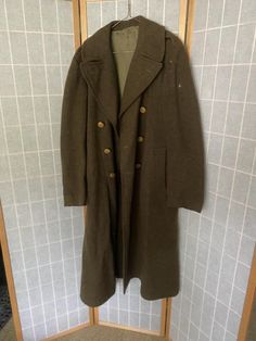 1950’s army green wool coat with eagle buttons. Has a repaired hole, rips on the inner neck, and a small pink stain. Being sold as isShoulders: 19”Shoulder to hem: 49” Historical Long Coat For Fall, Historical Fall Outerwear With Buttons, Military Style Wool Outerwear In Khaki, Military Wool Double-breasted Pea Coat, Military Style Wool Pea Coat With Button Closure, Winter Military Outerwear With Button Closure, Winter Military Outerwear With Buttons, Vintage Olive Outerwear With Buttons, Vintage Military Outerwear With Buttons