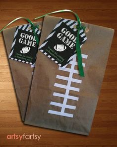 two brown paper bags with black and white footballs on them, tied to each other