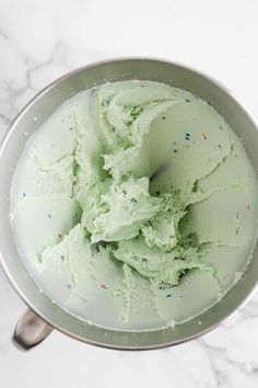 a metal bowl filled with green ice cream