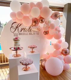 balloons and cake on display at a bridal shower party in pinks, golds and white