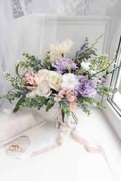 a bouquet of flowers sitting on top of a window sill