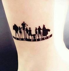 a tattoo on the ankle of a woman with four people riding horses and an arrow