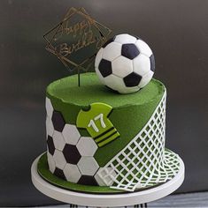 a soccer themed birthday cake with a soccer ball on top