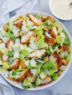 chicken caesar salad in a white bowl with dressing on the side and text overlay that reads homemade crispy chicken caesar salad