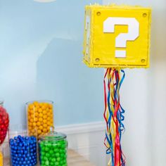 a table topped with lots of candy and a question mark sign on top of it