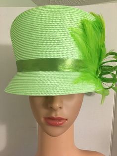 Formal, bright green, woven medium brim with a slant top, ribbon band, Sinamay ribbon and feather fan and rhinestone accent. Top hat style. 2 inch wide brim, 26 inches around, 7 inches inner width, 8 inches across top. Green Mini Hats For Spring Church Occasions, Spring Church Top Hat With Feathers, Green Mini Hats For Church In Spring, Green Summer Costume Hats And Headpieces For Church, Green Top Hat For Summer Church Events, Green Spring Hats For Church, Formal Summer Costume Hats With Feather Trim, Spring Formal Costume Hat With Feather Trim, Spring Formal Feather Trim Costume Hat