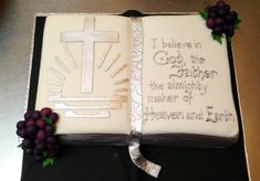 a cake decorated with grapes and an open bible