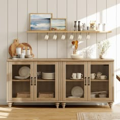 a wooden cabinet with plates and cups on it in front of a white painted wall