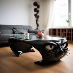 a glass table with a cat's face on it in front of a couch